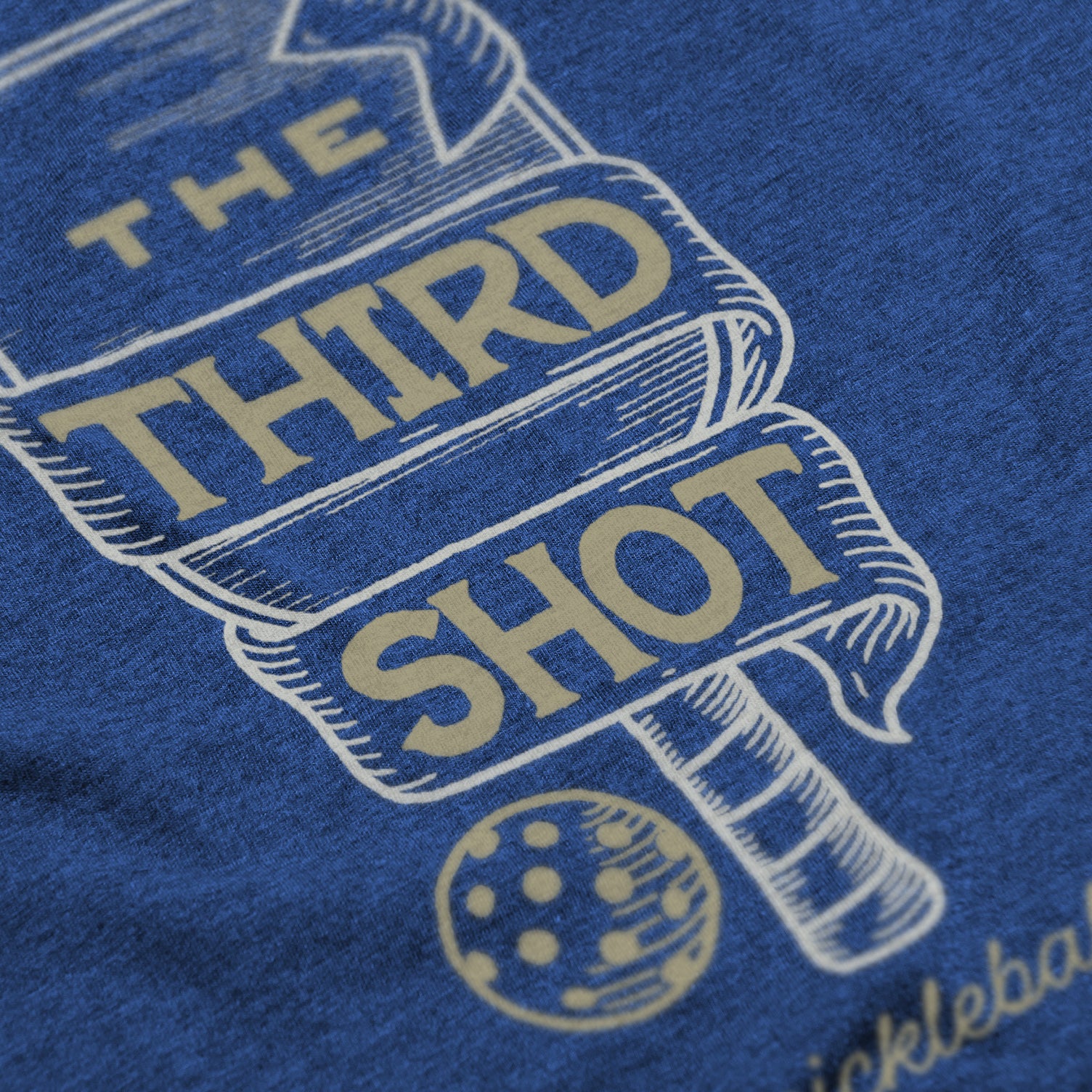 Close-up of Foundry pickleball shirt in royal – wood cut old fashioned paddle graphic detail on back