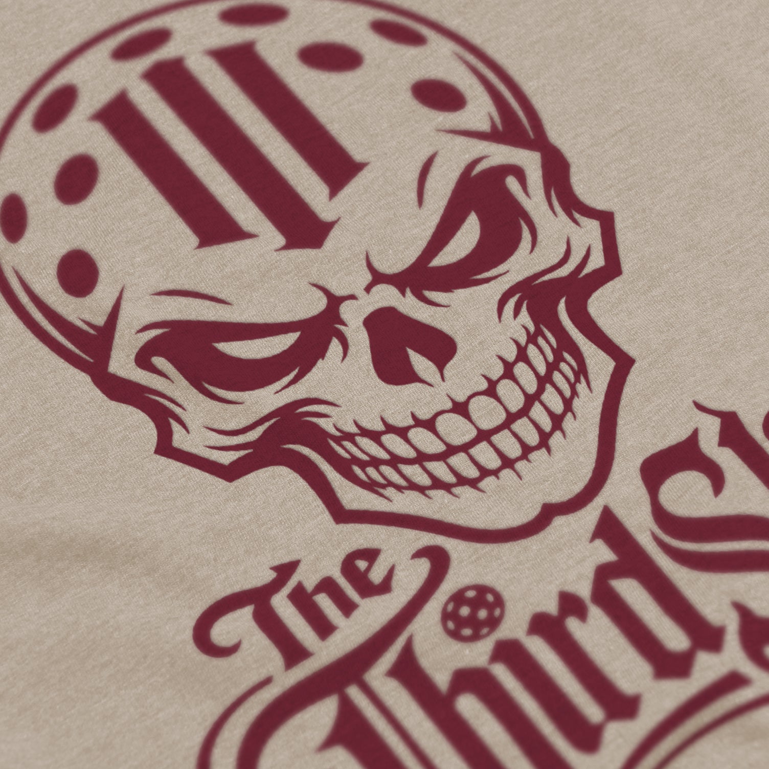 Close-up of Reaper pickleball shirt in cream – skull graphic detail on front