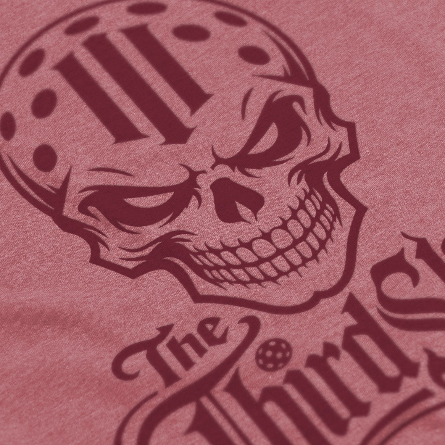 Close-up of Reaper pickleball shirt in mauve – skull graphic detail on front