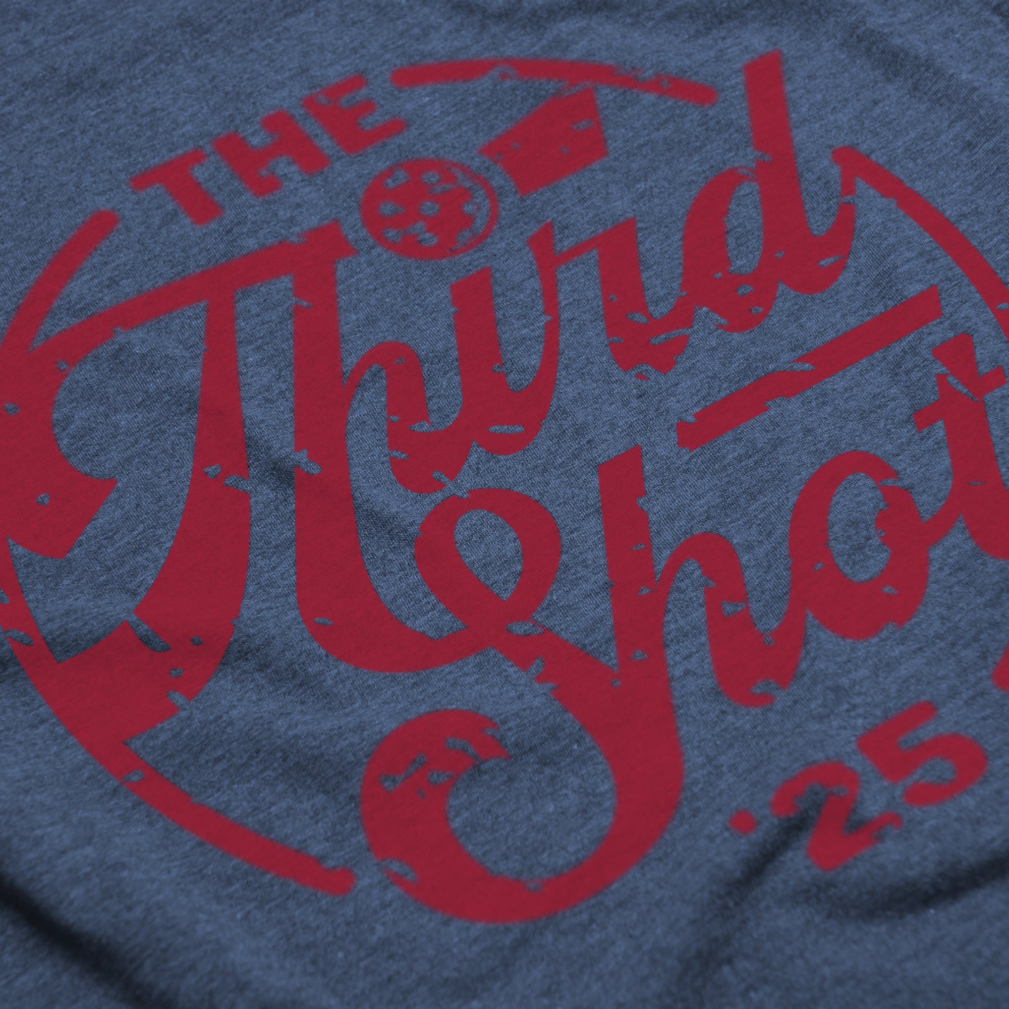 Close-up of Women’s Heritage pickleball shirt in indigo – retro circular logo detail
