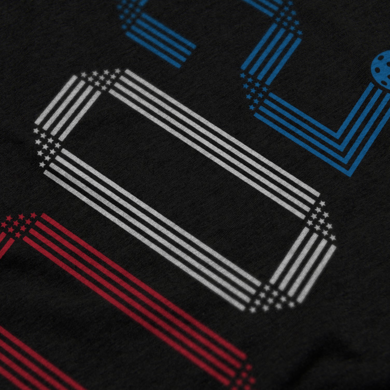 Close-up of Rise pickleball shirt in black – patriotic stars stripes score 002 graphic detail on front