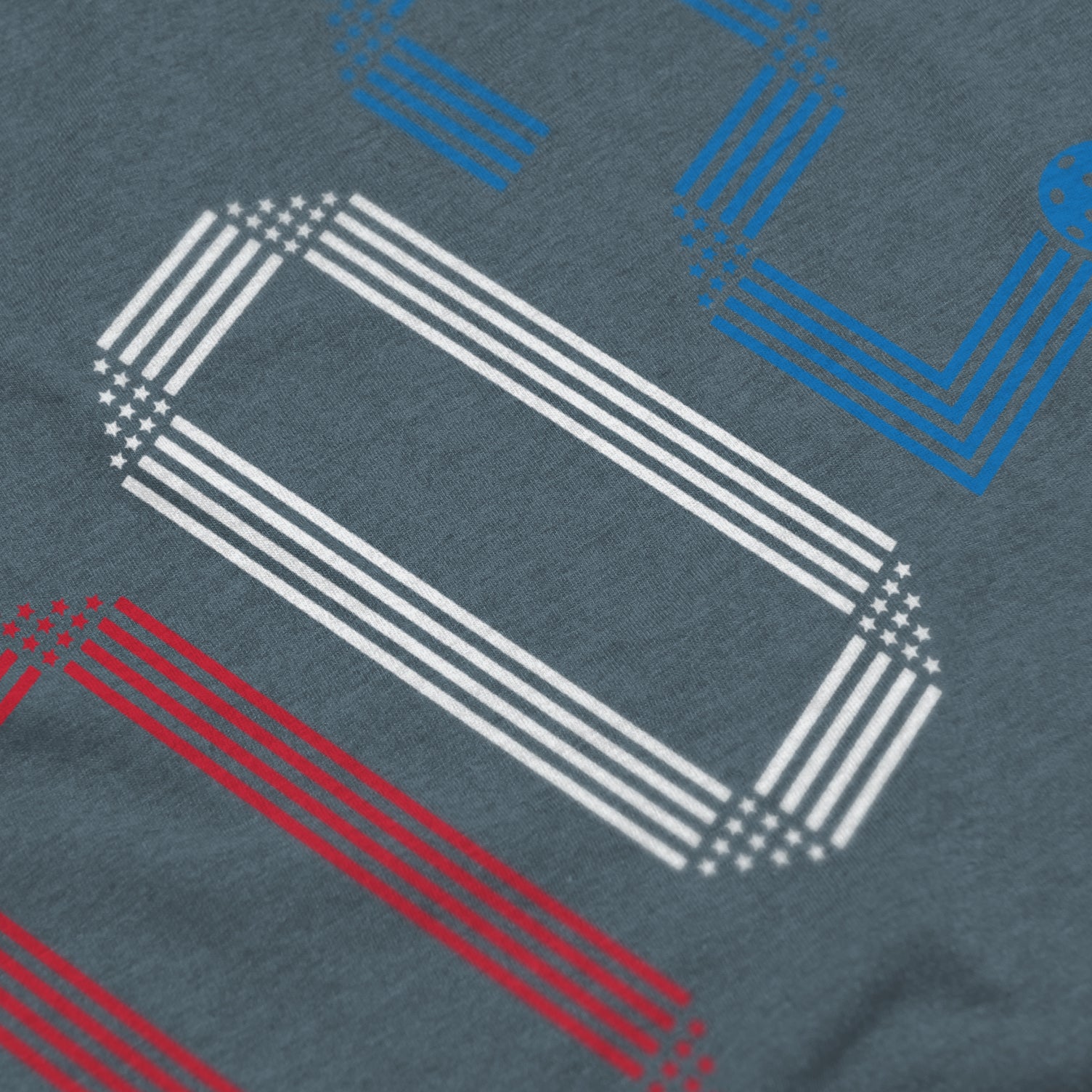 Close-up of Rise pickleball shirt in slate – patriotic stars stripes score 002 graphic detail on front