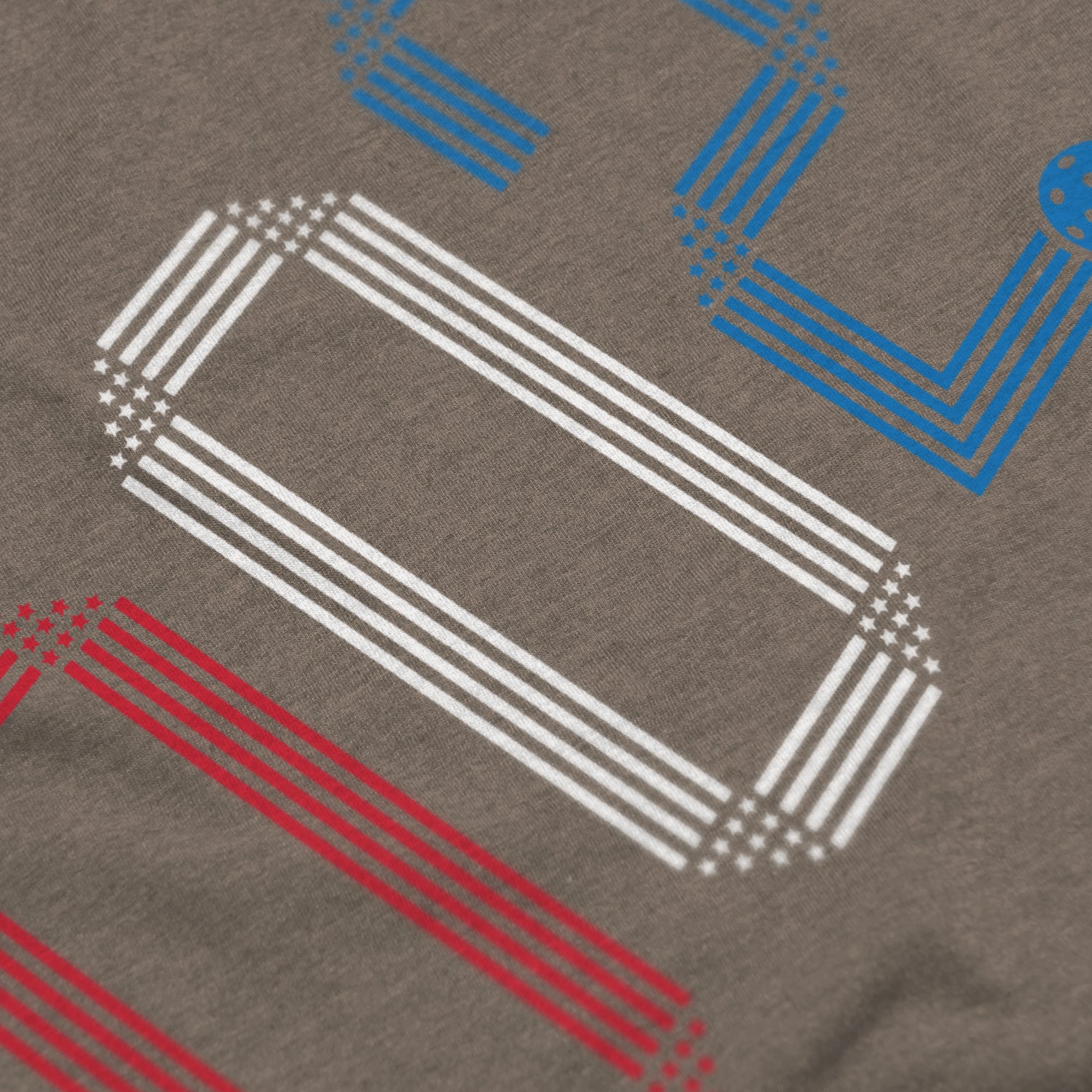 Close-up of Rise pickleball shirt in stone – patriotic stars stripes score 002 graphic detail on front